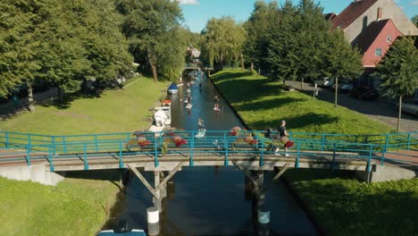 Turistas-Y-Lugareños-Disfrutando-Del-Paddleboarding-En-El-Canal-En-Las-Soleadas-Vacaciones-De-Verano,-Dolly-Out