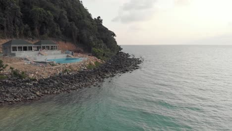 Fly-over-person-at-wooden-jetty,-LazyBeach,-Koh-Rong-Samloem,-Cambodia