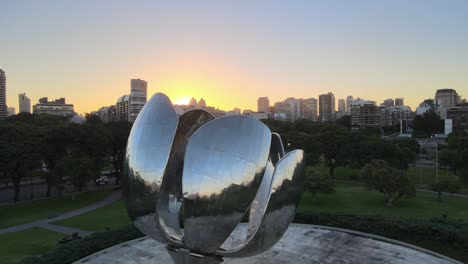 Jib-down-revealing-Floralis-Generica-steel-sculpture-with-Recoleta-buildings-in-background-at-golden-hour