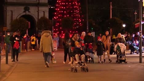 Nahaufnahme-Einer-Straße-In-Dublin-Zur-Weihnachtszeit-In-Schwierigen-Zeiten-Mit-Einigen-Menschen-Auf-Einer-Nicht-So-Belebten-Straße,-Mit-Der-Lokale-Unternehmen-Zu-Kämpfen-Haben,-Und-Einem-Weihnachtsbaum-In-Der-Mitte