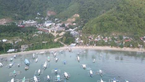 4K-Aerial-Drone-Shot-of-Outrigger-Banca-Boats-at-Corong-Corong-Beach-in-El-Nido,-Palawan,-Philippines