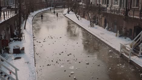 Gente-Patinando-Sobre-Hielo-En-Un-Canal-Congelado-En-Utrecht,-Países-Bajos