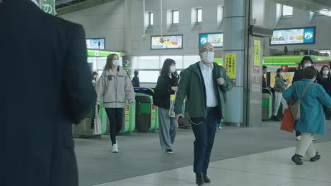 Puertas-De-Entrada-En-La-Estación-Shinagawa-Jr---Personas-Con-Máscaras-Viajando-En-Tokio,-Japón-Durante-La-Pandemia---Toma-Completa,-Cámara-Lenta