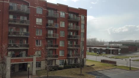 Montreal,-Canada---April-2-2020---Weird-sight-of-snow-falling-on-a-sunny-and-windy-day,-over-some-town-buildings