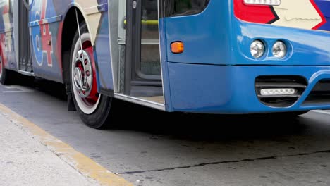 Colorido-Autobús-Cerrando-Puertas-Y-Salida-De-La-Estación-De-Autobuses-En-Buenos-Aires,-ángulo-Bajo