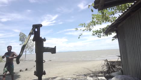 Plano-Medio-De-Un-Pozo-Entubado-En-La-Orilla-Del-Río-Que-Ayuda-A-Los-Aldeanos-A-Beber-Agua-Dulce-De