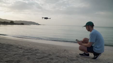 Hombre-Iniciando-El-Despegue-De-Un-Dron-En-La-Playa