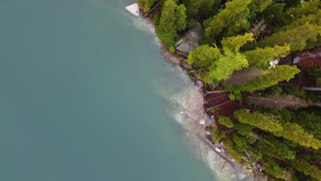 Drohnenaufnahmen-Vom-Colchuck-Lake-Und-Zwei-Drohnenbetreibern-Auf-Einem-Felsen-In-Der-Nähe-Der-Verzauberungen-In-Washingtons-Cascade-Mountain-Range-–-Moos-Und-Bäume-Wachsen-An-Der-Klippe