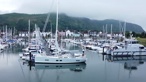 Luxusyachten-Und-Segelboote,-Die-Auf-Dem-Nebligen-Bergmassiv-Geparkt-Sind,-Ruhestandsdorf-Marina,-Absteigender-Schuss