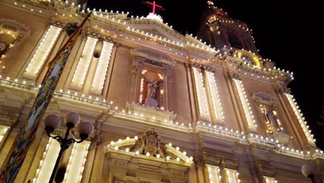 Malta,-middle-of-Sliema,-tilting-video-with-a-decorated-church-and-religious-rock-party-in-the-background-in-the-evening