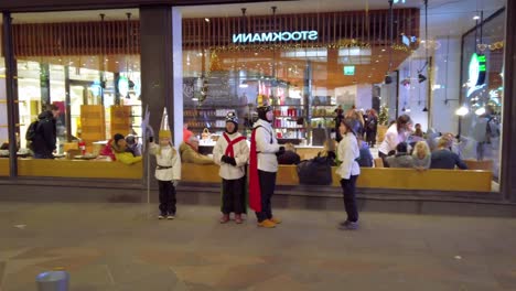 Finland,-Helsinki,-kids-playing-a-traditional-performance-show-at-night-before-Christmas-on-the-street