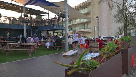 Blick-Auf-Die-Terrasse-Des-Mike-Hess-Brewing-Restaurants-In-Imperial-Beach,-Kalifornien,-Mit-Kunden,-Die-Spiele-Spielen-Und-Speisen