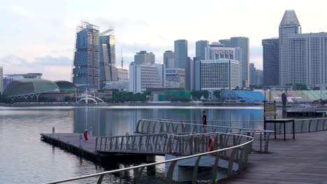 One-man-exercising-early-morning-at-Marina-Bay-Waterfront-Promenade,-beautiful-cityscape