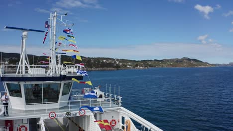 Norway-passenger-ferry-with-ships-dressing-signal-flags-at-constitution-day---Closeup-aerial