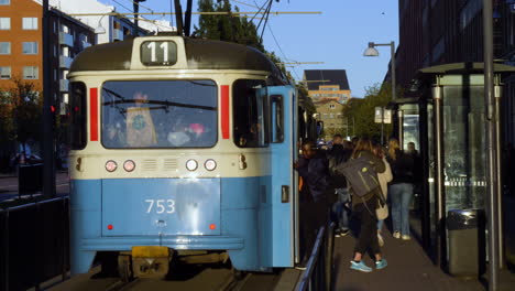 Slow-motion-shot-of-passenger-entering-and-leaving-Tram-Line-11-in-Gothenburg,-Sweden