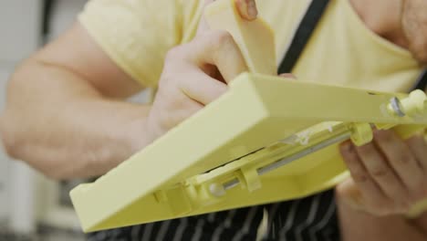 El-Chef-Corta-Queso-Usando-Una-Mandolina-Y-Sosteniéndolo-En-Sus-Manos.