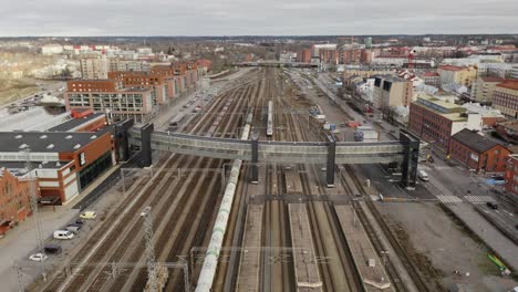 Aerial-view-of-passenger-train-passing-under-recently-opened-"Logomo"-bridge,-modern-glass-facade-architecture-and-design