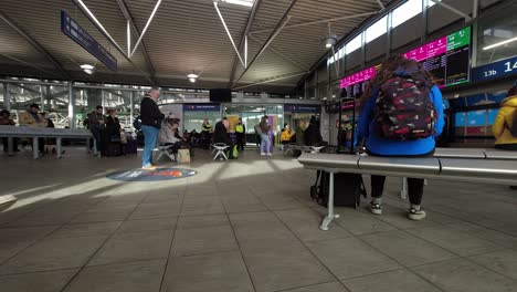 People-watching-platform-time-display-in-Manchester-Piccadilly-station-seating-area-time-lapse