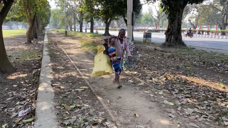 A-rag-picker-carrying-empty-paint-bucket-for-sale-in-Kolkata,-India