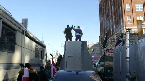 Men-with-fists-in-air-on-top-of-truck,-Freedom-Convoy-protest,-Ottawa