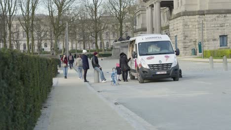 Queue-of-People-at-The-Belgian-Waffle-and-Ice-Cream-Truck,-Food-Van-Selling-Hot-Waffles-and-Ice-at-the-Jubelpark-in-Brussels,-Belgium