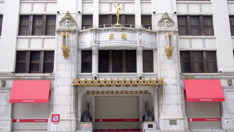 TOKYO,-JAPAN,-circa-April-2020:-pedestrians-walking,-cars-driving-in-front-of-prestigious-department-store,-Nihonbashi-Mitsukoshi-with-bronze-lions,-at-old-downtown-in-central-financial-district,-day