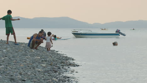 Padre-Asiático,-Hija-Y-Otras-Personas-Jugando-En-Una-Costa-Rocosa