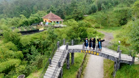 Four-women-on-bridge-at-Klangon-hill-on-graduation-day,-Yogyakarta-in-Indonesia