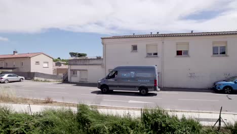 Pressure-water-cleaning-van-heading-to-water-tower,-Aerial-pan-left-follow-shot