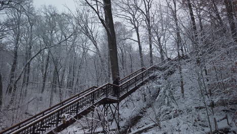 Weitwinkelaufnahme-Eines-Joggers,-Der-Bei-Schneefall-Eine-Hohe-Treppe-In-Der-Schlucht-Von-Glen-Stewart-Hinaufsteigt