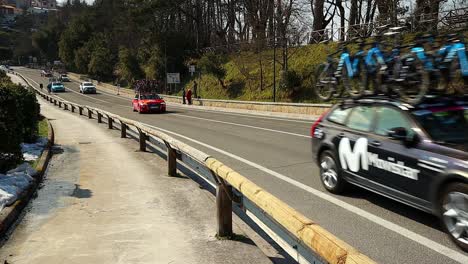 Auf-Der-Straße-Fahren-Autos-Von-Radrennteams-Mit-Fahrrädern-Auf-Dem-Dach-Vorbei