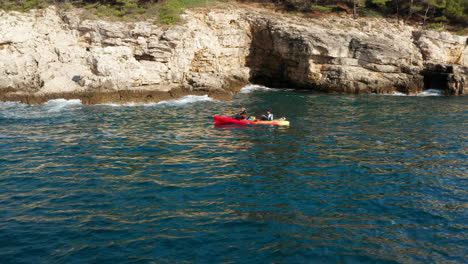 Kajakfahren-Im-Meerwasser-In-Der-Nähe-Der-Klippen-Und-Höhlen-In-Pula,-Kroatien-–-Weitwinkelaufnahme