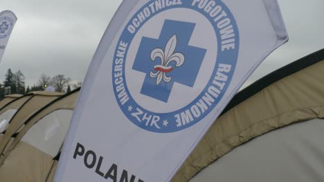 Die-Flagge-Des-Flugrettungsdienstes-Weht-Im-Wind,-Wo-Freiwillige-Bei-Der-Rettung-Helfen,-Am-Basislager-Für-Flüchtlinge-Am-Ukrainisch-polnischen-Grenzübergang-In-Medyka,-Provinz-Karpatenvorland