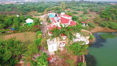 Disparando-Un-Dron-De-Un-Centro-Vacacional-Con-Lujosas-Casas-Blancas,-Lago-Y-Piscina-En-Vadodara,-India,-Rodeado-De-árboles-Y-Vegetación-Verde