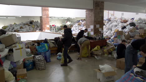 Los-Voluntarios-Clasifican-Bolsas-De-Ropa-Donada-En-El-Palacio-De-Arte-De-Lviv,-Que-Se-Ha-Convertido-En-El-Centro-De-Ayuda-Más-Grande-De-La-Región-Durante-La-Guerra-Rusa-Contra-Ucrania.