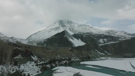 Aerial-Dolly-Over-Hunza-River-With-View-Of-Epic-Snow-Capped-Mountain-In-Distance