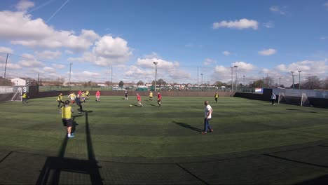 Grupo-De-Amigos-Jugando-El-Partido-De-Fútbol-Del-Domingo-Por-La-Mañana-En-Goals-Ruislip-En-Londres