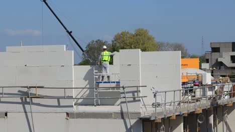 Muro-De-Apoyo-Que-Están-Construyendo-Los-Trabajadores-De-La-Construcción-Con-Una-Grúa-Pequeña-Y-Grandes-Ladrillos-Blancos-Prefabricados-En-El-Sitio-De-Construcción-Como-Parte-Del-Plan-De-Desarrollo-Urbano-Del-Barrio-De-Noorderhaven