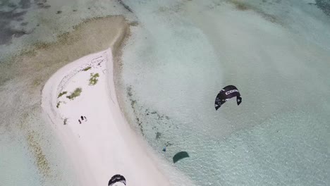 Man-kiteboarding-learns-to-stand-on-sand-with-turquoise-waters,-aerial-view-los-Roques