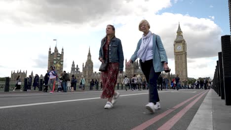 Blick-Aus-Der-Tiefwinkelansicht-Auf-Die-Geschlossene-Westminster-Bridge,-Geschäftige-Menschen,-Die-Darüber-Laufen,-Und-Das-Parlament-Im-Hintergrund