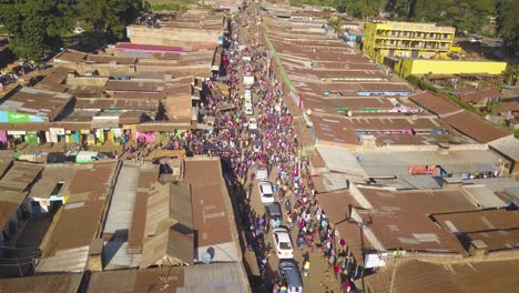 A-Huge-Gathering-of-People-Following-Politican-Cars,-Aerail-Wide-Drone-shot