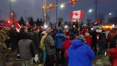 gliding-shot-truckers-and-residents-in-freedom-convoy-at-night-in-Windsor,-ontario,-canada-on-February-11,-2022