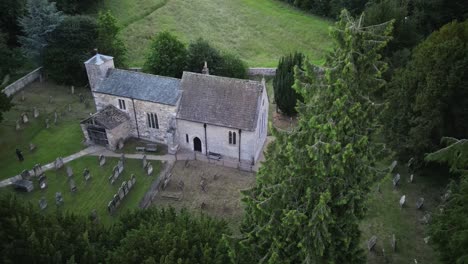 Slow-aerial-descent-towards-ancient-porch-entrance-at-historic-church-iat-Kirkdale-in-North-Yorkshire