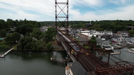 Una-Vista-Aérea-Sobre-El-Puente-Ferroviario-Del-Río-Saugatuck-En-Connecticut-En-Un-Hermoso-Día-Con-Nubes-Blancas