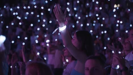 Primer-Plano-De-Una-Mujer-Divirtiéndose-En-Una-Gran-Multitud-En-Un-Concierto-Con-Un-Espectáculo-De-Luces