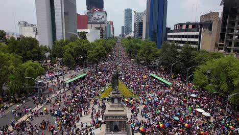 Aerial-view-in-front-of-the-crowded-Monumento-a-Cuitlahuac,-in-Mexico-city---ascending,-drone-shot