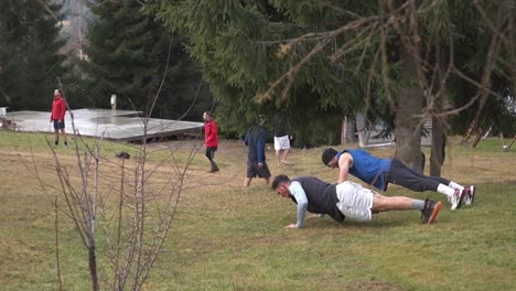 Hombres-Haciendo-Flexiones-En-El-Césped-Afuera-En-El-Parque