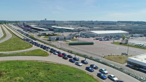 BMW-M5-E39-Owners-Group-line-up-to-race-in-Dingolfing,-Germany-in-celebration-of-the-M5-series-50th-anniversary---aerial-view