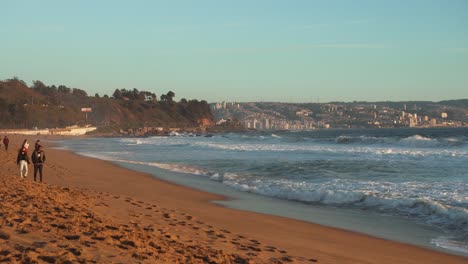 Menschen,-Die-Während-Der-Goldenen-Stunde-In-Valparaiso,-Chile,-Am-Strand-Von-Reñaca-Spazieren-Gehen