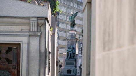 Engel-Und-Drei-Männer-Halten-Tagsüber-Eine-Flaggenmausoleumsstatue-Auf-Dem-Friedhof-Von-La-Recoleta-Und-Kippen-In-Die-Höhe